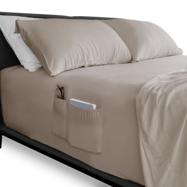 sábana de cajón king size almaya inteligente ajuste perfecto mod almendra sábana ajustable color almendra, vista 3/4 frontal de cama con dobladillo elástico ceñido; tela lisa de alta suavidad, bolsillo lateral doble con gafas y un libro visibles, diseño con 4 bandas elásticas para ajuste perfecto, adecuada para mantener accesorios organizados junto a la cama.