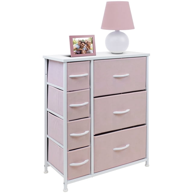 sorbus cómoda con 7 cajones, mueble de almacenaje y cómoda para recámara en color rosa — Cómoda Sorbus rosa en vista frontal 3/4 con marco de acero blanco; tres cajones grandes a la derecha y cuatro cajones pequeños a la izquierda en tela no tejida con tiradores de madera; medidas aprox. 63.5 cm x 30 cm x 73.5 cm; cajones plegables, requiere montaje mínimo; también suele usarse como organizador compacto para juguetes y ropa de niños.