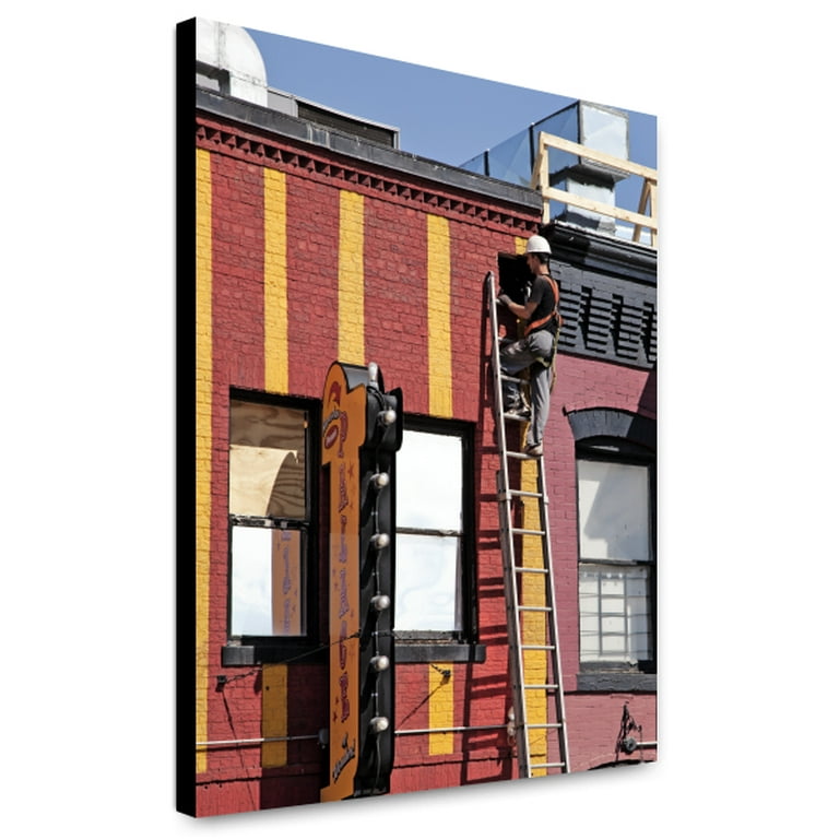 Man on ladder, working on a building, H St. near intersection with