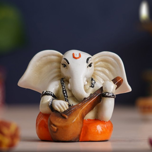 Polyresin Handcrafted Lord Ganesha Idol Playing Veena Musical Instrument, White & Orange
