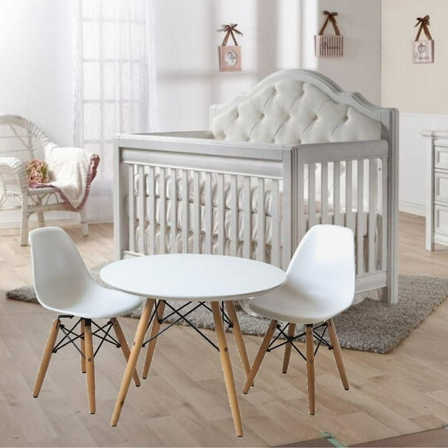 Kids workstation set featuring a round white tabletop with natural wood legs and two matching white chairs, placed in a bright nursery room.
