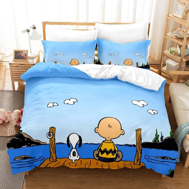 gp1 snoopy 3 en 1 juego de ropa de cama sábana edredón funda de dormitorio lavable cómodo traje de casa pg1 juego de cama 3 piezas con diseño de Snoopy y Charlie Brown sentados en un muelle frente a un lago y cielo azul con nubes; incluye funda de edredón 150x200 cm y dos fundas de almohada 50x75 cm, mostrado sobre una cama en habitación iluminada.