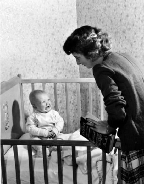 Mother Standing At Crying Baby Boy Sitting In Crib Poster Print