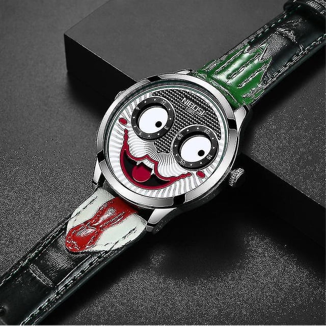 reloj de pulsera de cuarzo con esfera grande para hombre, diseño de cara de payaso resistente al agua de cuero — Vista frontal centrada con carátula de payaso: dos discos blancos como ojos, sonrisa roja en relieve y patrón texturizado; caja metálica plateada, corona a la derecha y correa de cuero estampada en verde, blanco y rojo. A menudo usado como accesorio de moda.
