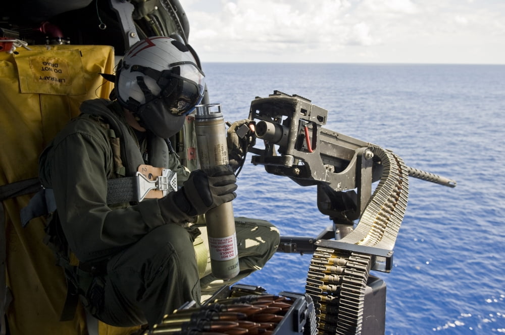 Naval Aircrewman manning a 50 caliber machine gun aboard a MH-60 Seahawk Canvas Art - Stocktrek Images (34 x 23)