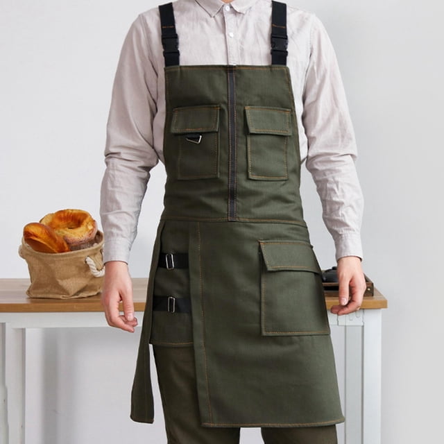 delantal industrial perfecl resistente al aceite de lona verde — vista frontal de torso y piernas con delantal de lona verde que cubre del pecho a las rodillas (60 x 75 cm); correa ancha y tirantes cruzados ajustables, parte inferior dividida para facilitar el movimiento, tres bolsillos múltiples y anillas metálicas para herramientas; ideal para taller, soldadura ligera, jardinería y cocina; a menudo se usa también en peluquería canina.