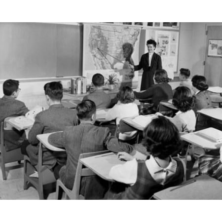 - Female teacher pointing to a map in a classroom Poster Print