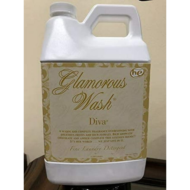 DIVA Glamorous Wash Détergent à Lessive Fin 64 oz Demi-Gallon par Tyler Candles, Exposé dans une Pichet Blanche avec une Étiquette Or et Crème. Ce Détergent Hypoallergénique et Sans Produits Chimiques Est Écoresponsable et Convient aux Tissus Délicats, aux Vêtements de Bébé et aux Linges. Il Élimine les Odeurs, Adoucit les Tissus et Fonctionne avec des machines à Laver Haute Efficacité.