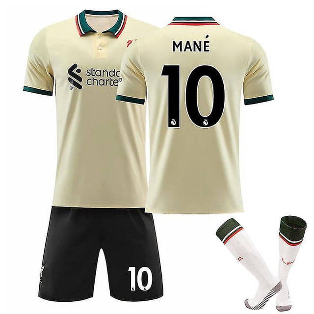 camiseta de fútbol liverpool fc mane no.10 para jóvenes/niños, camiseta de visitante 2021/22: frontal y trasera centradas de camiseta beige con cuello polo a rayas verdes y rojas; espalda con MANÉ y número 10 negro; conjunto con short negro con 10 blanco y calcetines blancos con puño verde y detalle rojo, adecuada para entrenamiento juvenil o uso en partidos informales.