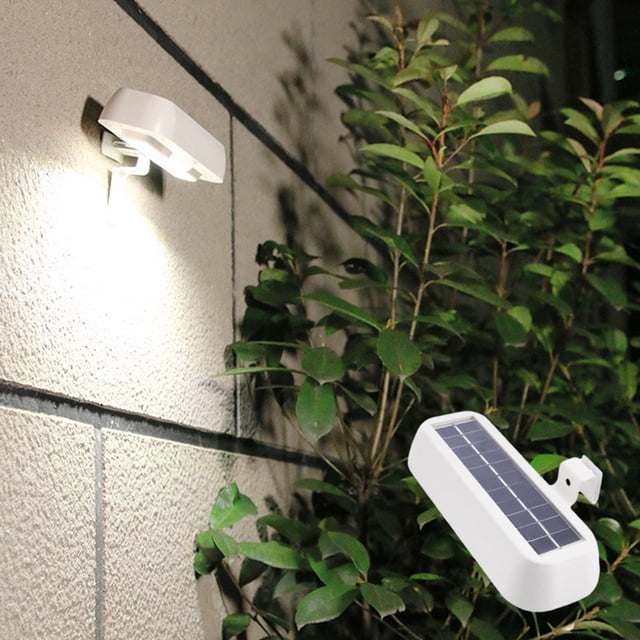 CQCYD Clearance under $5 Solar Lights Outdoor LED Solar Motion Sensor Lights mounted on a wall near plants, emitting bright light. The white ABS plastic light features a solar panel for charging and is ideal for outdoor lighting, including fences, roofs, gutters, gardens, and yards. It offers IP65 watertight protection, ensuring durability in various weather conditions, and operates for up to 8 hours when fully charged, making it suitable as a security light.