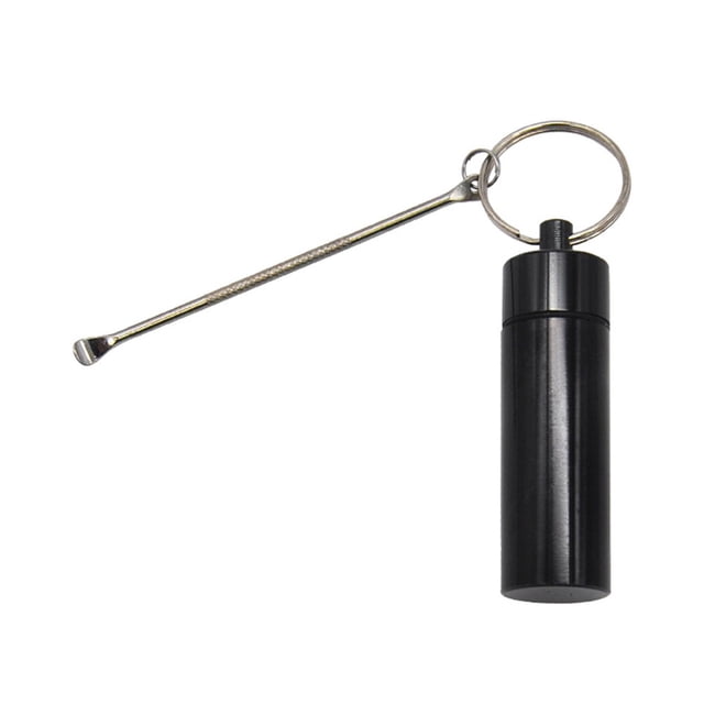 llavero pastillero pequeño mini para suplementos medicamentos negro zulema estuche de medicamentos Llavero pastillero cilíndrico negro de metal, vista frontal centrada con tapa roscada; dimensiones aproximadas 55 x 17 mm, superficie metálica lisa, anilla metálica y espátula/extractor plateada sujeta al aro; fondo blanco. Tamaño portátil, adecuado para llevar pastillas o cápsulas y suele usarse también como adorno de bolso.