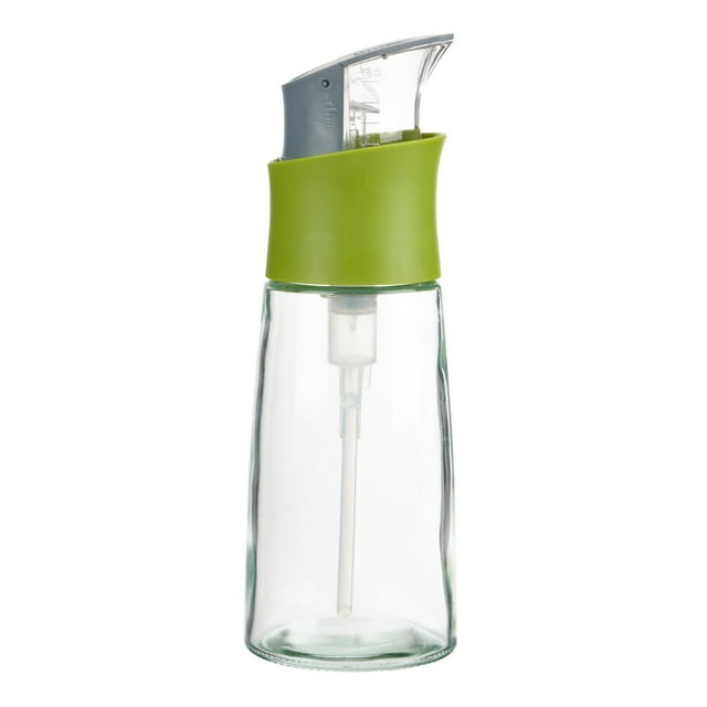 Clear glass Trudeau Press & Measure Oil Bottle with green silicone grip and gray press top for precise oil dispensing.