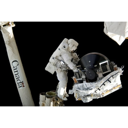 An astronaut anchored to the foot restraint on the Canadarm2 Stretched Canvas - Stocktrek Images (34 x