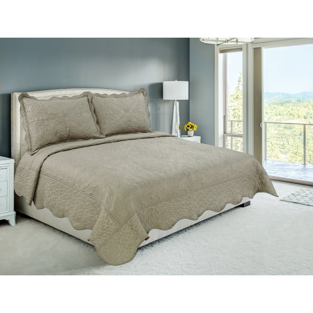 Taupe floral paisley embroidered coverlet bedspread and quilted shams set displayed on a neatly made bed in bright bedroom.