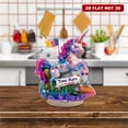 thumbnail image 1 of Rotating acrylic display featuring a unicorn with a Trans Rights sign on glitter grass adorned with translucent resin layers and falling transgender flags, 1 of 8
