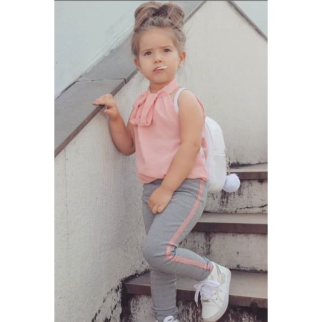 Toddler Kids Baby Girls Clothes Set with an off-shoulder ruffle lace pink top featuring bowknot detail and striped plaid pants. Designed for toddler girls aged 2T-5T, this 2-piece outfit set is ideal for casual occasions. The child is styled with white sneakers and a white backpack while standing on stairs.