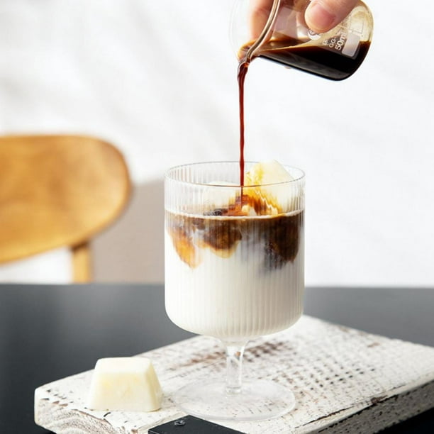 Quatre petits desserts tiramisu dans des coupes en verre avec une affiche  de jardin de