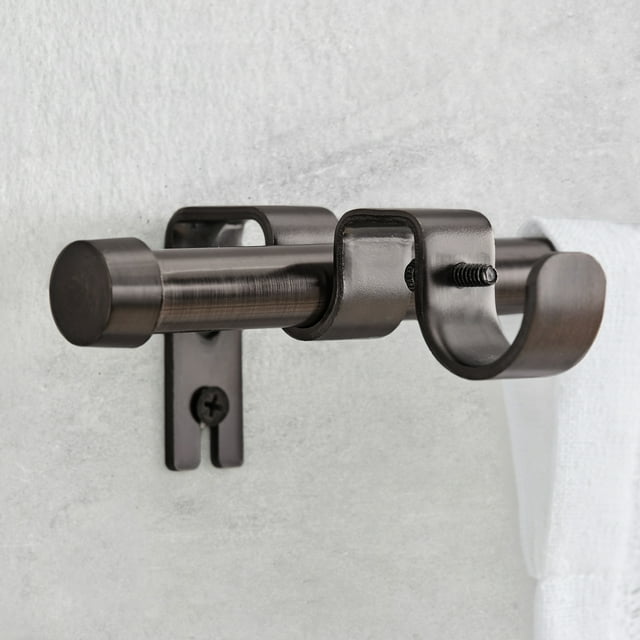 Better Homes & Gardens oil rubbed bronze adjustable add-on curtain rod bracket mounted on wall holding a white curtain.