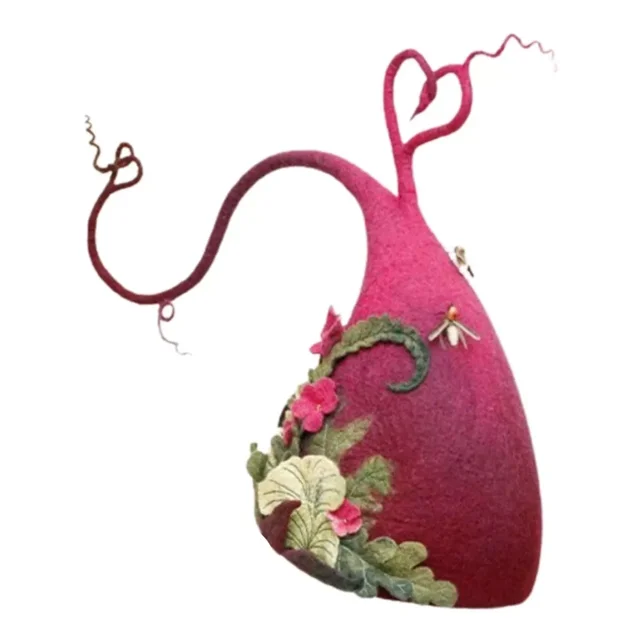 sombreros de bruja divertidos unbrand para halloween Rosa chicle cónico asimétrico, vista frontal de perfil; fieltro rosa chicle con punta curva que forma un lazo en corazón, tallos rizados decorativos y apliques de hojas y flores verdes y rosas en la base. También suele usarse como accesorio lúdico para sesiones fotográficas temáticas.
