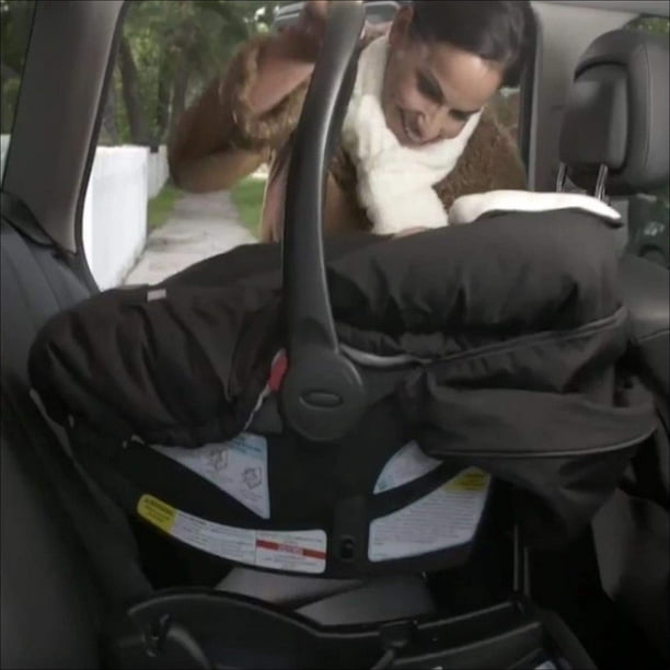 bébé fille ceinturé dans une sécurité enfant voiture siège, sourit tandis  que à la recherche à
