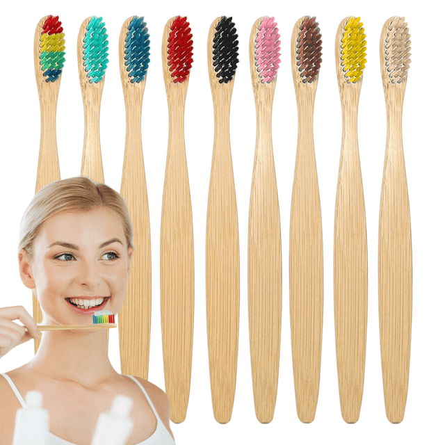 50pz cepillos dientes infantiles bambú biodegradable suave — lote de 50 cepillos con mangos de bambú claro en fila frontal y cabezales de cerdas extra suaves multicolor (arcoíris, turquesa, azul, rojo, negro, rosa, café, amarillo, natural). Vista centrada y frontal que muestra mango ergonómico liso y cerdas de corte recto; fondo blanco con persona parcialmente recortada. Suele usarse como cepillo infantil para viajes o reemplazo por lote.
