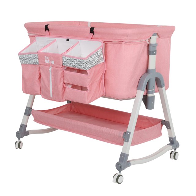 cuna colecho para bebe tipo corral con mecedora 5 niveles de altura ajustables baby gaon bczn02 cuna colecho rosa en vista 3/4, estructura blanca y gris con ruedas y patas en A, bandeja de almacenamiento inferior y bolsillero frontal con cambiador integrado y paneles ventilados con mosquitero; función mecedora y altura ajustable en 5 posiciones, plegable para transporte; también suele usarse como corral supervisado para juegos breves.