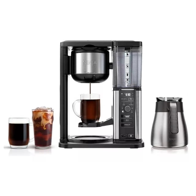 cafetera ninja maquina de cafe frio y caliente 10 tazas frontal centrada de la Cafetera Ninja Smart Scoop negra, depósito de agua transparente a la derecha y panel de controles vertical con pantalla y botones, tolva metálica con logo Ninja sobre el porta-filtro, jarra térmica de acero inoxidable separada a la derecha y tres vasos delante mostrando café caliente y café helado; diseño compacto, controles para ajustar fuerza, tamaño y temperatura según especificaciones, y suele usarse también para preparar concentrados fríos para bebidas y cócteles de café.