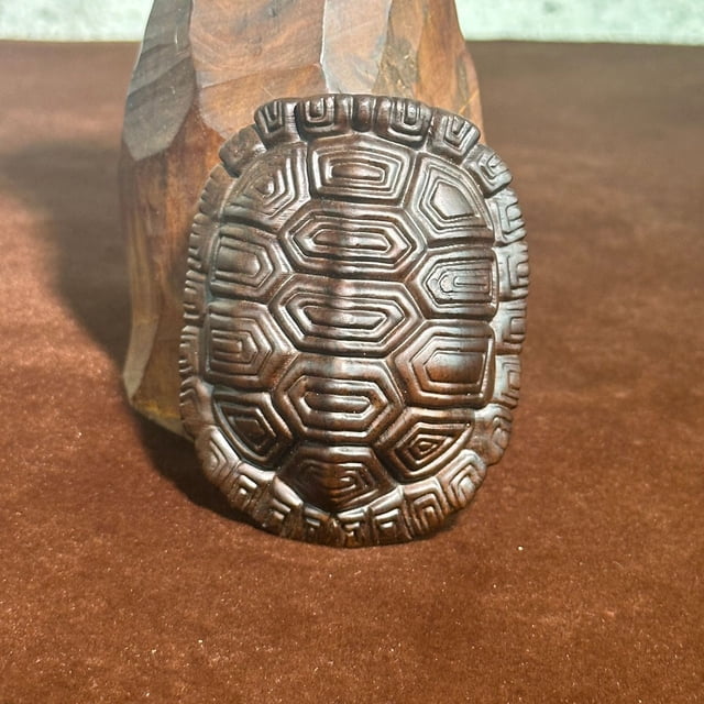 Ebony wood carving, a tortoise shell ornament symbolizing wealth and prosperity, a collectible item, a handheld piece, a home decoration, a creative handicraft.