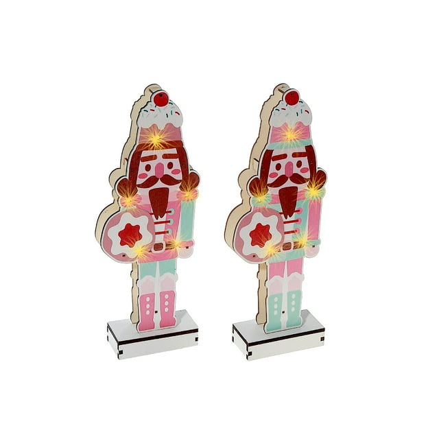 Set of two LED wooden nutcracker stands in pastel pink and blue, decorated with lights and holding star-shaped cookies.