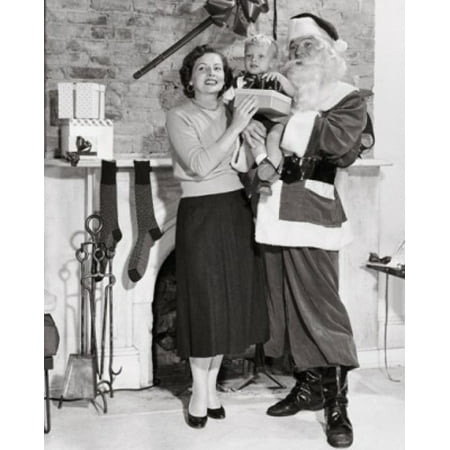 Mid adult man dressed as Santa Claus standing with his wife and son Poster Print (18 x 24)