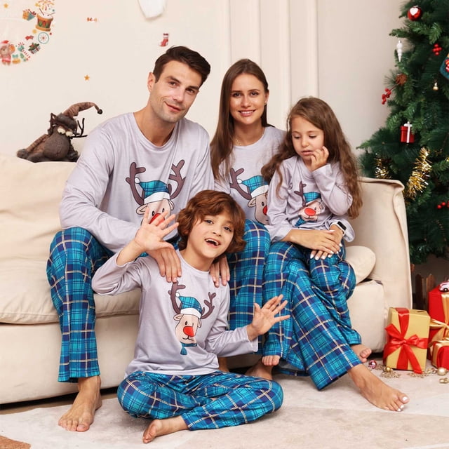 RKSTN Christmas Pajamas for Family featuring matching long-sleeve tops and pants with cute elk and snow prints. The kids' set includes a grey top with a reindeer design and blue plaid pants, made from soft polyester fabric. Ideal holiday pajamas for festive photos, Christmas parties, or casual wear. Displayed in a cozy living room with a decorated Christmas tree and wrapped gifts.
