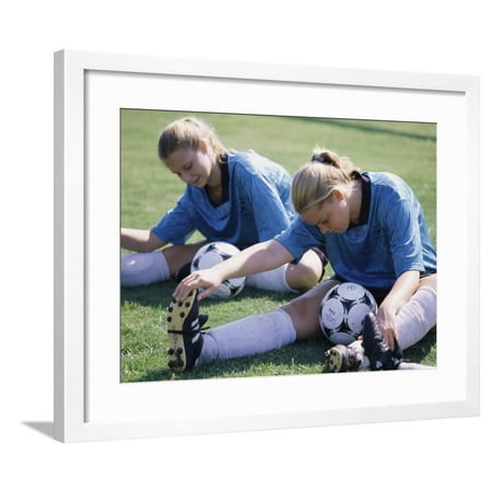 Teenage Girls in Soccer Uniforms Doing Stretching Exercises Framed Print Wall