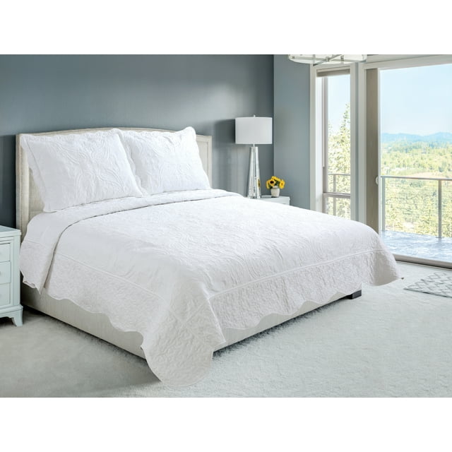 Ultra soft white embroidered coverlet bedspread and quilted shams with floral paisley pattern displayed on a king-size bed in bright bedroom.