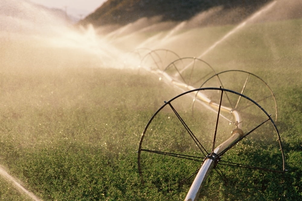 Sprinkler system with wheels watering crops Poster Print (18 x 24