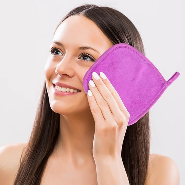 toalla cuadrada pequeña absorbente de agua, toalla de limpieza facial, toalla desmaquillante para personas perezosas, toallita desmaquillante — Vista 3/4 de una persona sujetando la toallita cuadrada absorbente de color magenta con borde cosido y trabilla; textura suave visible, tamaño aprox. 15 x 15 cm, mostrada en uso para limpieza facial y retiro de maquillaje sobre fondo neutro de estudio; también adecuada como paño compacto para viajes o retoques rápidos.