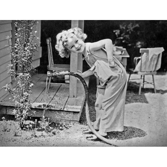 Shirley Temple Posed in Jumper suit watering flowers Photo Print (8 x 10)