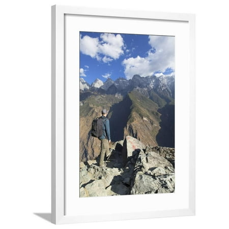 Man hiking in Tiger Leaping Gorge, UNESCO World Heritage Site, with Jade Dragon Snow Mountain (Yulo Framed Print Wall Art By Ian