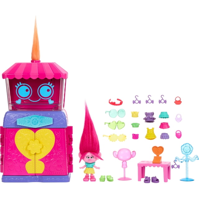 playset mattel dreamworks trolls fun fair surprise con queen poppy multicolor playset con muñeca de moda Queen Poppy, casa boutique rosa y morada con techo a rayas y puerta amarilla en forma de corazón; muñeca Poppy de cabello alto fucsia y vestido verde, 25 accesorios desplegados como gafas, vestidos, zapatos, perchero y mesa de exhibición, fondo blanco.