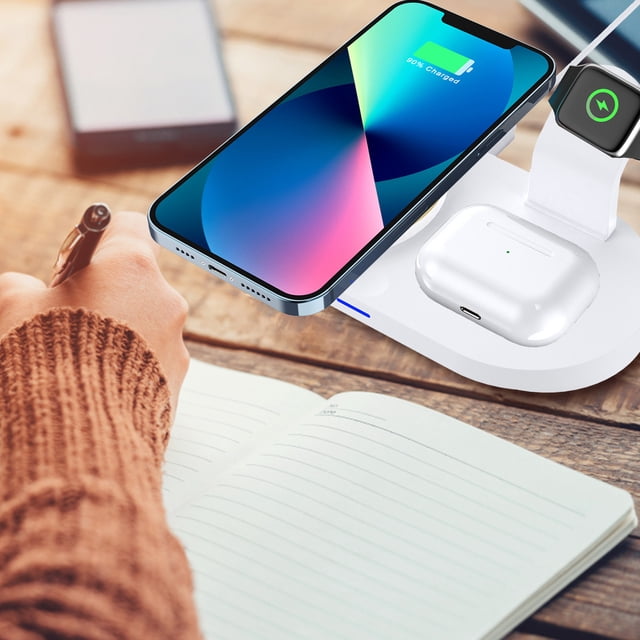 cargador inalámbrico, cargador inteligente inalámbrico multifuncional cuatro en uno para ios, teléfono móvil, reloj, auriculares de escritorio, cargador rápido inalámbrico de 15 w, soporte para teléfo — vista 3/4 de un cargador inalámbrico blanco cuatro en uno sobre un escritorio. Base ovalada de ABS con plataforma magnética que muestra un teléfono iOS en carga, almohadilla frontal para estuche de audífonos con puerto USB-C visible, soporte trasero con ícono de carga para reloj y LED de estado encendido; cable tipo-C conectado. También suele usarse como estación compacta para mantener teléfono, reloj y audífonos organizados en escritorios y mesas de noche.