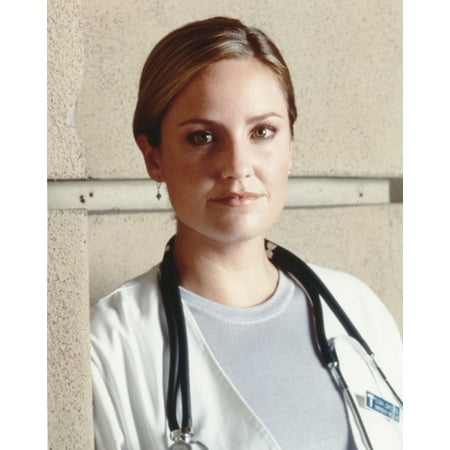 Sherry Stringfield Posed in White Long Sleeve Coat and Grey Round Neck Shirt with Stethoscope Around the Neck Photo