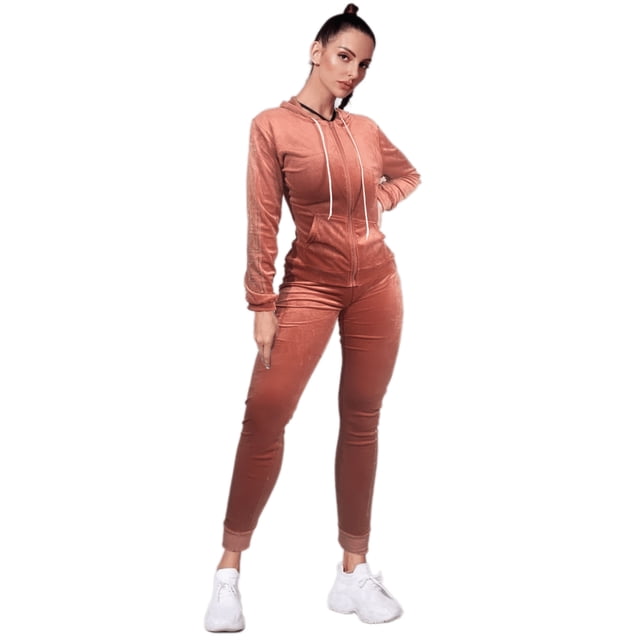 conjunto pants mujer sudadera y pant aterciopelado set dama Coral Lole; vista frontal 3/4 con modelo de pie. Sudadera con cierre central, capucha y cordones blancos, bolsillos frontales y tejido aterciopelado stretch. Pants tiro alto con pretina reforzada, corte ajustado y puños enrollados; combinado con tenis blancos sobre fondo blanco. Adecuado para deporte ligero o uso casual.
