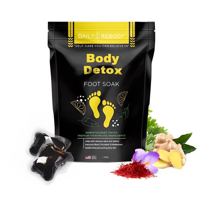 herbal detox foot soak (1 pack / 5 perlas) paquete vertical negro con texto amarillo 'Body Detox Foot Soak' y huellas amarillas; cinco perlas negras visibles junto a jengibre, hebras de azafrán y una flor morada sobre fondo blanco, presentación para baño de pies y spa casero, adecuado para rutinas de relajación en el hogar.