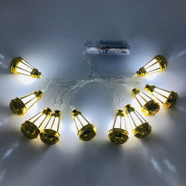 10 LED Ramadan Lantern String Lights, featuring warm white illumination and gold oil lamp-style lanterns connected by transparent cables. Battery-operated with a compact AA battery pack visible. Total length of 165cm, ideal for indoor festival lighting, Eid celebrations, home parties, or window displays.