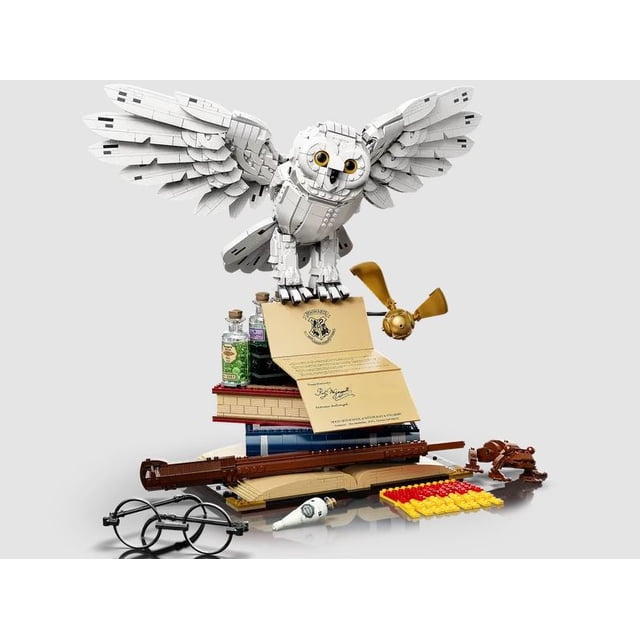 No Name Hawgorts Magical Collectors Ion Edition Display Building Blocks (3010 PCS), an educational toy featuring a life-size owl replica with outstretched wings atop a stack of spell books, potion bottles, and accessories like a wand, scarf, and glasses. Includes three custom minifigures and original display box, ideal for learning and imaginative play.