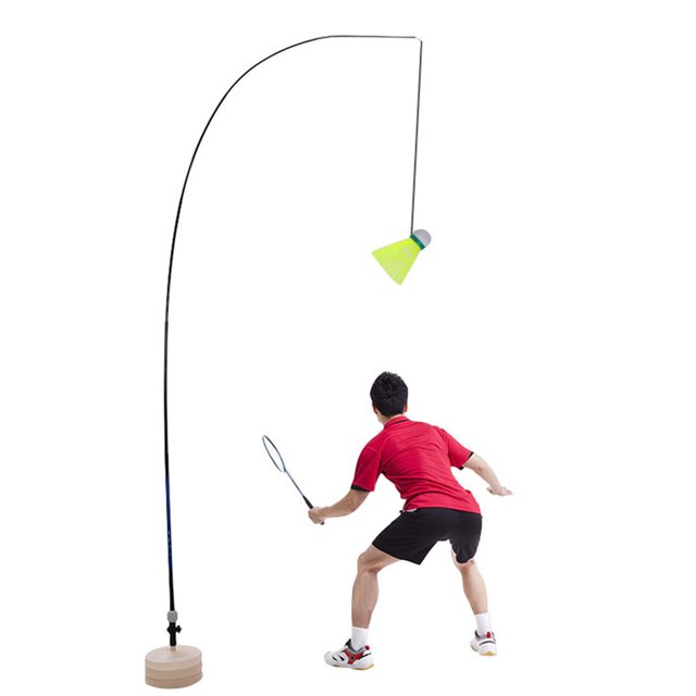 Badminton Trainer Solo Equipment Practice Training Aid featuring a telescopic elastic pole with a height of up to 3.3m, a water-filled base for stability, and an attached shuttlecock for self-study badminton practice. The image shows a person in a red shirt and black shorts using the trainer in an indoor setting. The trainer is lightweight, durable, and suitable for adults, seniors, and children, making it ideal for playgrounds, parks, or home use.