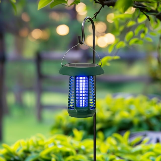Sunjoy solar and battery powered garden insect killer lantern emitting blue light, hanging outdoors among green plants.