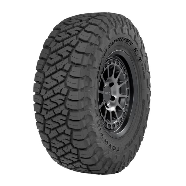 llanta 35x12.50r22 lt toyo open country rt trail 121q — vista 3/4 frontal de llanta Toyo montada en rin 22", dibujo todoterreno con bloques escalonados y canales de evacuación pronunciados, flanco con texto "OPEN COUNTRY R/T" y marca Toyo visible, fondo blanco. A menudo usada también como opción para vehículos 4x4 y expediciones off-road debido a su dibujo agresivo.