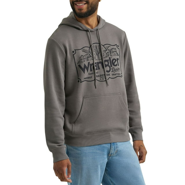 Gray Wrangler men's graphic hoodie featuring a western-themed logo, worn by smiling man with light blue jeans.