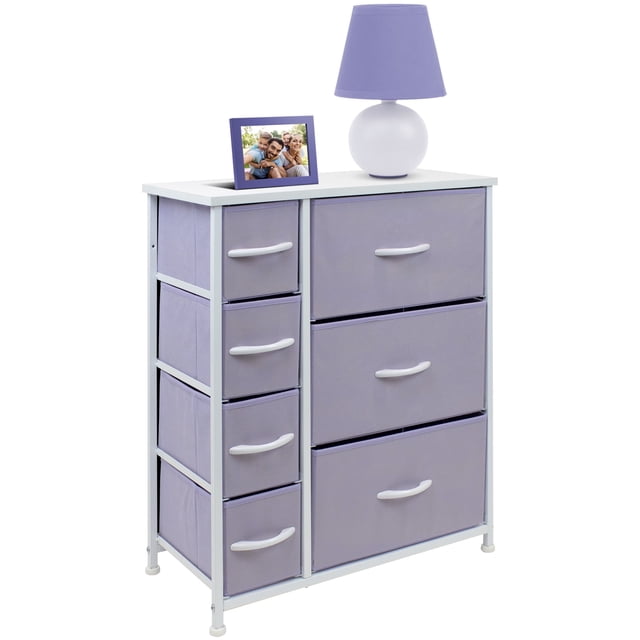 sorbus cómoda con 7 cajones, mueble de almacenaje y cómoda para recámara en color morado — Cómoda frontal 3/4 con marco de acero blanco y superficie MDF blanca; tres cajones grandes de tela morada a la derecha y cuatro cajones plegables a la izquierda con asas blancas, cajones de tejido no tejido. Accesorios mostrados no incluidos. Dimensiones aprox. 25" x 11.87" x 28.75". Suele usarse para organizar ropa, mantas, juguetes o materiales de manualidades.