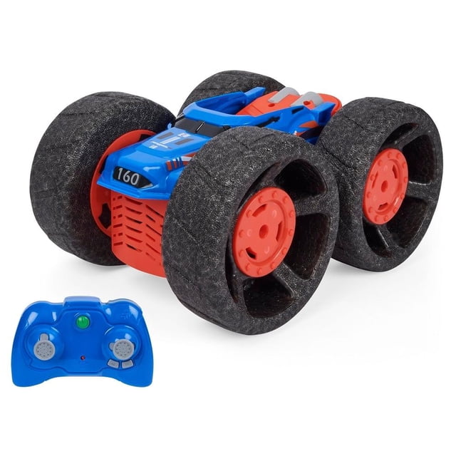 vehículo radio control spin master air hogs jump shot azul, vista 3/4 frontal de carro RC con carrocería azul y acentos rojos, cuatro neumáticos anchos de espuma negra y llantas rojas, control remoto azul con dos mandos en primer plano; salta hasta 22 pulgadas, diseñado para acrobacias y fácil de controlar, requiere pilas tipo AAA. También suele usarse para prácticas de maniobra en espacios abiertos.